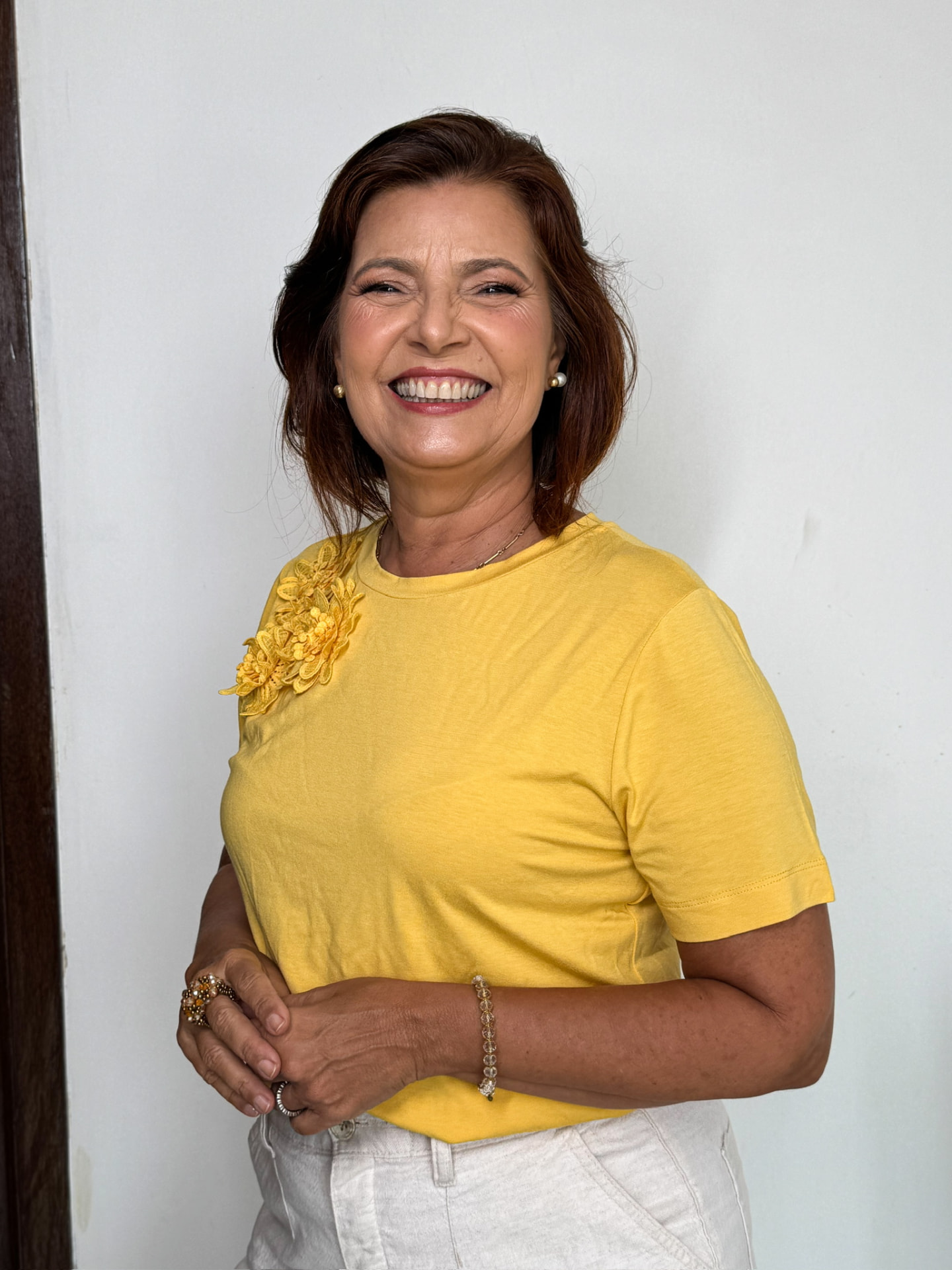 Adélia Pinheiro sorrindo, de blusa amarela